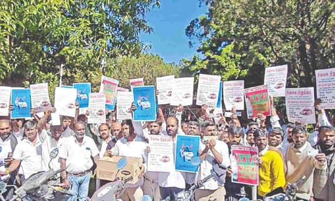 Taxi drivers stage a demonstration near the Collectorate in Ooty on Monday