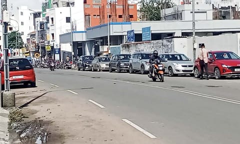 Two wheelers and cars parked on both sides of the Tiruvottiyur High road&nbsp;