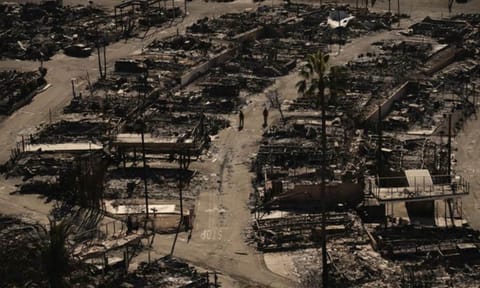 Firefighters walk along a road in a fire-ravaged community in the aftermath of the Palisades Fire in the Pacific Palisades neighborhood of Los Angeles&nbsp;