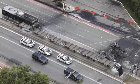 The crash site of a small plane, right, that burned a bus, left, covers an avenue in Sao Paulo (AP)&nbsp;