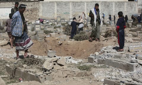 Yemenis watch a hole at Magel Al-Dammah cemetery a day after it was struck by U.S air strikes in Sanaa, Yemen (AP)&nbsp;