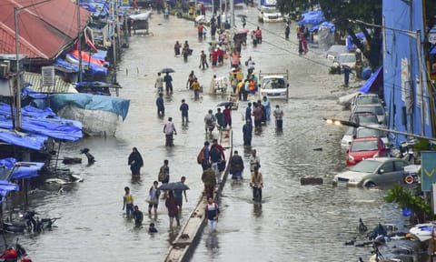 People wade through a waterlogged road amid rains at Byculla, in Mumbai, Monday, May 26, 2025 (PTI)&nbsp;