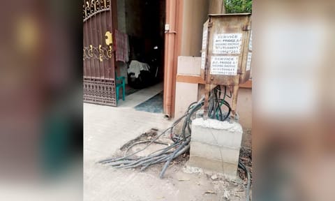 Loose cable wires left hanging from the junction box by the roadside in Union Carbide Colony