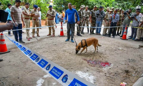 Police and security personnel with a sniffer dog stand guard at a cordoned area where CPI leader K Chandu Naik was shot dead (PTI)&nbsp;