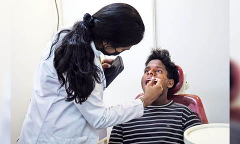 A beneficiary getting his teeth checked at the medical camp held at St Bede's Anglo Indian Higher Secondary School, Santhome&nbsp;