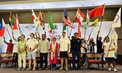 Officials and surfers onstage waving their country’s flags after the sand pouring ceremony&nbsp;&nbsp;