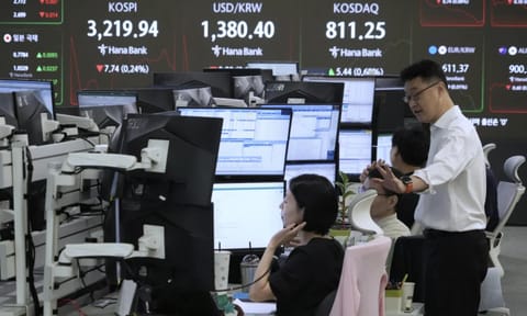 Currency traders work near a screen showing the Korea Composite Stock Price Index (KOSPI), top left, and the foreign exchange rate between U.S. dollar and South Korean won, top center, at the foreign exchange dealing room of the Hana Bank headquarters in Seoul, South Korea, Friday, Aug. 8, 2025 (AP)&nbsp;