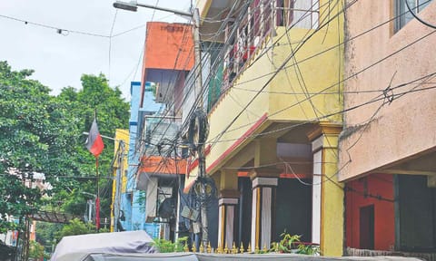 Criss-crossing, loosely hanging fibre cables across Ganapathy Street in West Mambalam