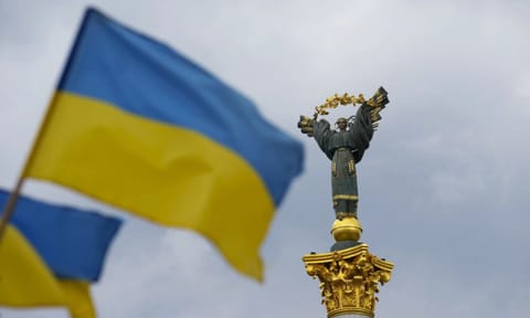 The Independence Monument is pictured as Ukrainian flags blow in the wind in Kyiv, Ukraine, on Saturday (AP)