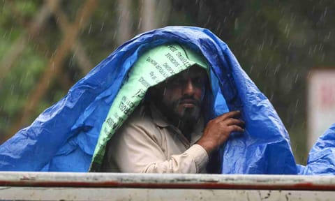 A man covers himself with a plastic sheet amid rainfall, in Jammu, Sunday, Aug. 31, 2025 (PTI)&nbsp;