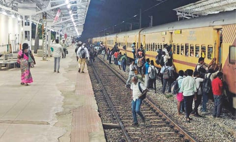 Passengers board express train from the non-boarding side of platform 1 at Tiruvallur station