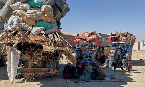 Afghan refugees sit next to their belongings loaded onto vehicles as they wait for opening of the border crossing point, which closed following Afghan and Pakistani security forces exchanged cross border firing, at a camp in Charnan, Pakistan, Sunday, Oct. 12, 2025. (AP Photo)