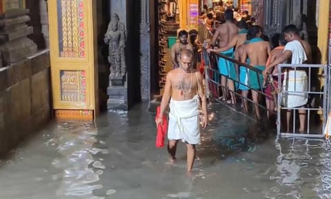 Devotees wade through rain water that entered the Tiruchendur temple on Thursday&nbsp;