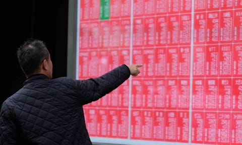 A person loots at an electronic stock board showing Japan's Nikkei index at a securities firm Monday, Oct. 27, 2025, in Tokyo (AP)&nbsp;