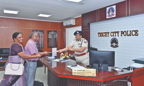 Tiruchy City Commissioner of Police N Kamini handing over the statement of account copy to victim Raja Perumal on Monday