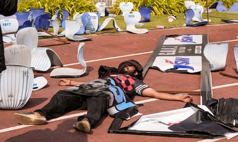 A person lays amidst broken chairs following chaos during an event of Argentine footballer Lionel Messi as part of his 'G.O.A.T. India Tour 2025', at Vivekananda Yuba Bharati Krirangan (VYBK), in Kolkata, Saturday, Dec. 13, 2025. Fans protested after failing to catch a clear glimpse of the footballer despite paying hefty sums for tickets. (PTI)&nbsp;&nbsp;
