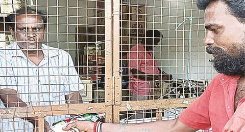 A customer receives Rs 10 after returning an empty liquor bottle at a Tasmac shop in Yercaud on Thursday