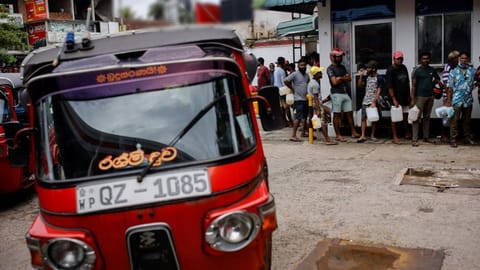 People wait in a queue to buy petrol at a fuel station, amid the country's economic crisis in Colombo, Sri Lanka