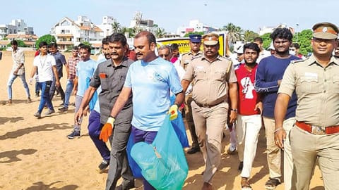 Union Minister L Murugan picking up waste from Besant Nagar beach as part of the Coastal Cleanup Day initiatives.