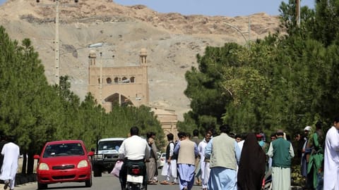 Afghan people gather near the site of an explosion