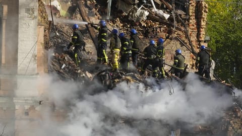 Firefighters try to extinguish a fire after a drone fired at buildings in Kyiv, Ukraine, Monday.