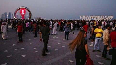 People take photographs in front of the official FIFA World Cup Countdown Clock