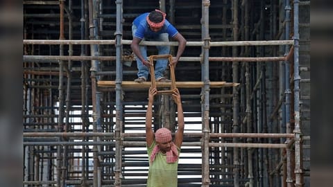 Labourers work at the construction site of a residential building