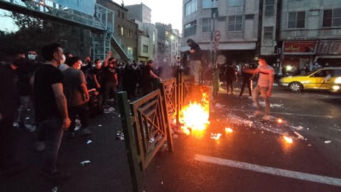 People light a fire during a protest over the death of Mahsa Amini