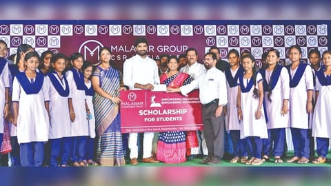 In the backdrop of the image, one can see a banner of the Trust which is part of the Malabar Group.