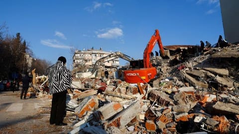 A person looks at rubble and debris following an earthquake in Kahramanmaras