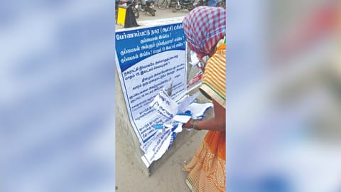 A worker removing the posters in  Pernambut Municipality on Thursday