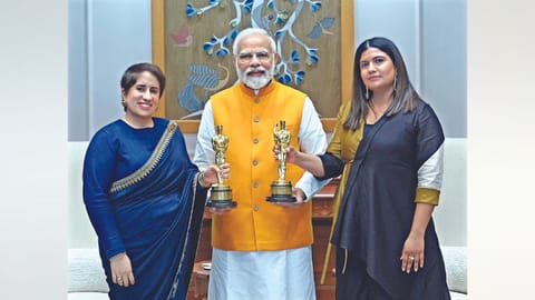 Prime Minister Narendra Modi with The Elephant Whisperers producer Guneet Monga (l) and director Kartiki Gonsalves in New Delhi Thursday