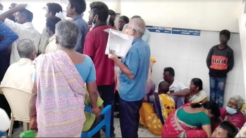 Differently abled person and attendants standing in line at Vellore Government Medical College