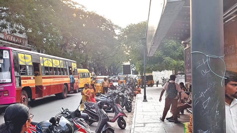 An MTC service stopped in the middle of the road as two-wheelers occupy space near the bus stand in Pondy Bazaar