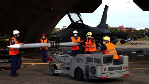 Air force soldiers load a U.S. made AIM-120 Advanced Medium-Range Air-to-Air Missile