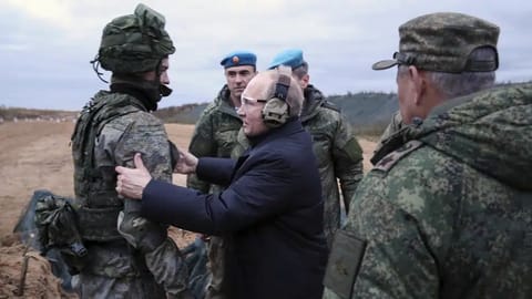 Russian President Vladimir Putin speaks to a soldier as he visits a military training center