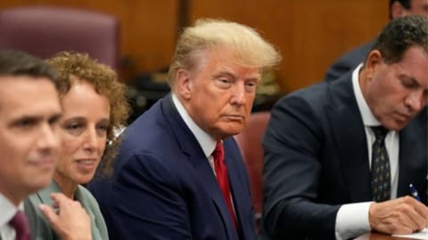 Wearing a dark blue suit and red tie, Trump, the first sitting or former U.S. president to face criminal charges