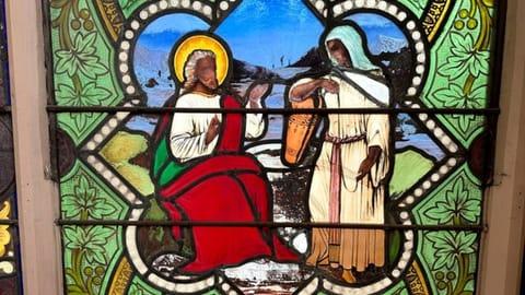 A detail of a nearly 150-year-old stained-glass window that depicts Christ speaking to a Samaritan woman, in the now-closed St. Mark's Episcopal church, in Warren, R.I.