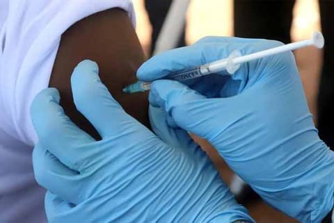 A WHO worker administers a vaccination during a campaign aimed at beating an outbreak of Ebola