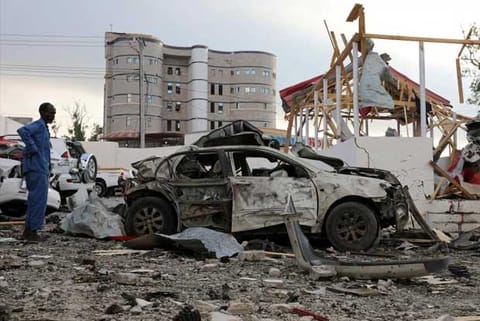 A security officer from Doorbin Hotel assesses the debris after a suicide car explosion