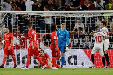 Real Madrid's Thibaut Courtois and team mates react after conceding a goal scored by Sevilla's Andre