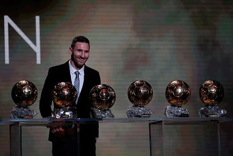Barcelona?s Lionel Messi poses with his six golden balls during the Golden Ball award ceremony in Paris