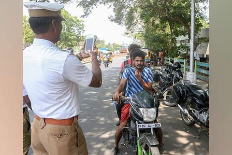 A policeman takes photograph of youth riding triples on a two-wheeler using the new device on Friday