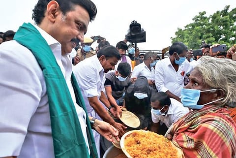 DMK chief Stalin serving food to an old woman affected by rain in Cuddalore, on Saturday.