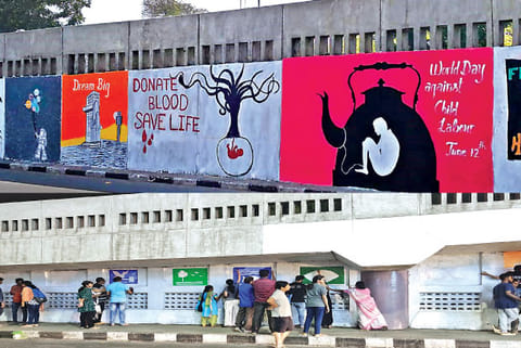 Volunteers painting murals on the walls of the flyover