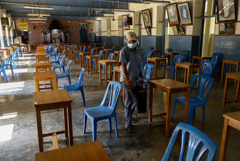A sanitation staff disinfecting examination hall