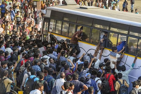 Passengers rush to board an express bus after lockdown announcement at Koyambedu bus terminal