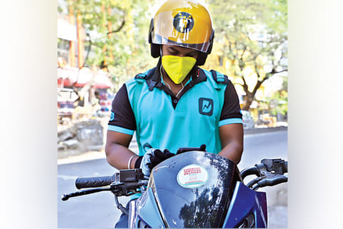 An executive of a popular app waits for orders in Chennai on Sunday