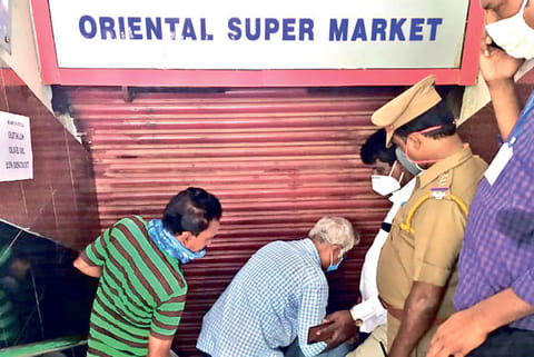 Officials sealing the supermarket for not following social distancing and other lockdown rules