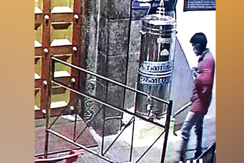 Video grab of the intruder praying beforethe deity before breaking open the hundial